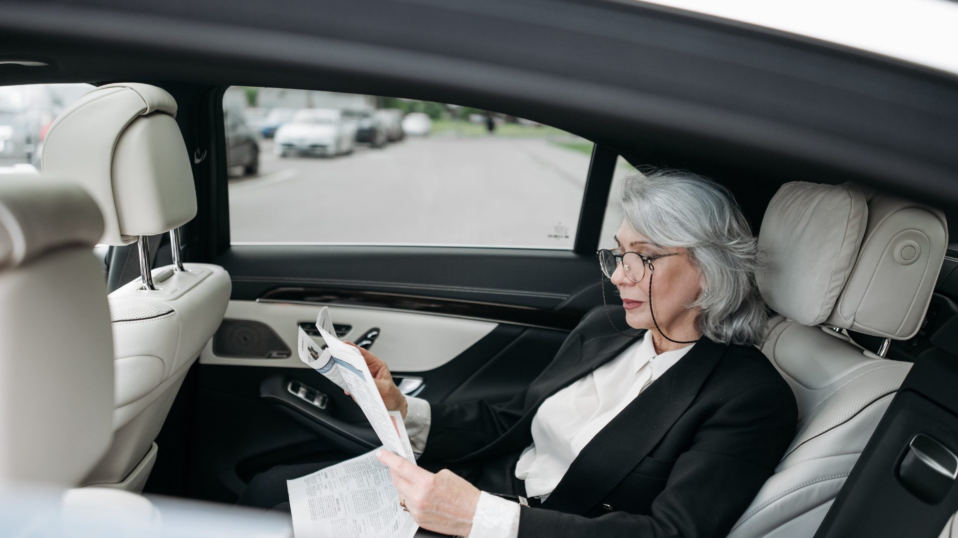 business woman in a car looking at paperwork